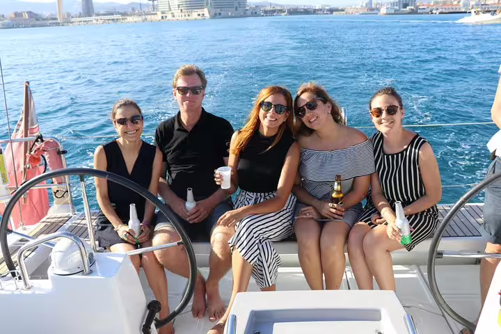Group enjoying drinks on a sunny small group cruise with ocean views, perfect for a relaxing 2-hour sailing experience.