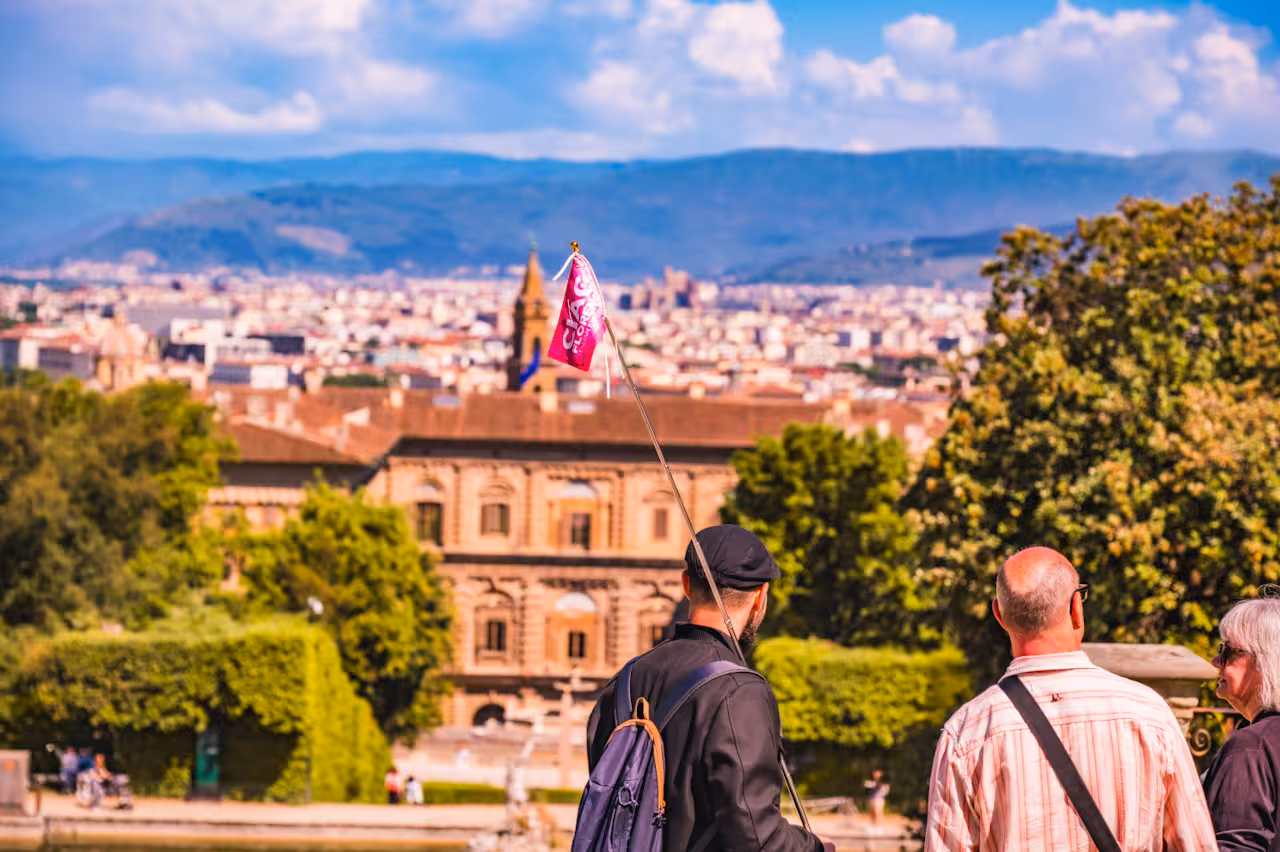 Small group exploring Pitti Palace with scenic view of Florence and lush greenery on a guided tour.
