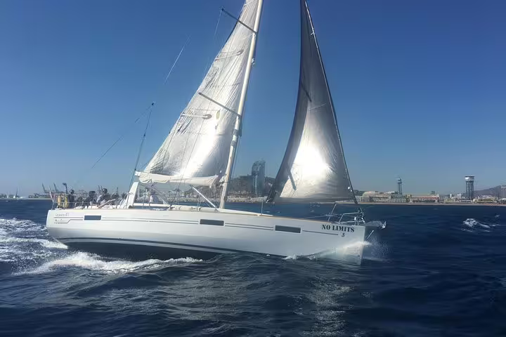 Sailboat cruising on a sunny day with city skyline in the background, offering a 2-hour small group tour with food and drinks.