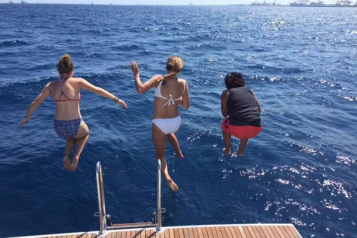 Guests enjoy a thrilling leap into the ocean from a yacht during a 2-hour small group cruise with food and drinks onboard.