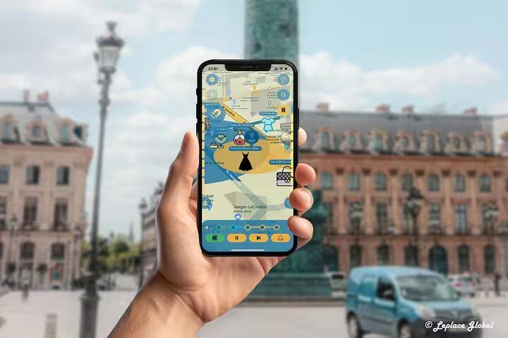 Hand holding smartphone displaying Paris fashion history walking tour app with interactive map near Place Vendôme Paris