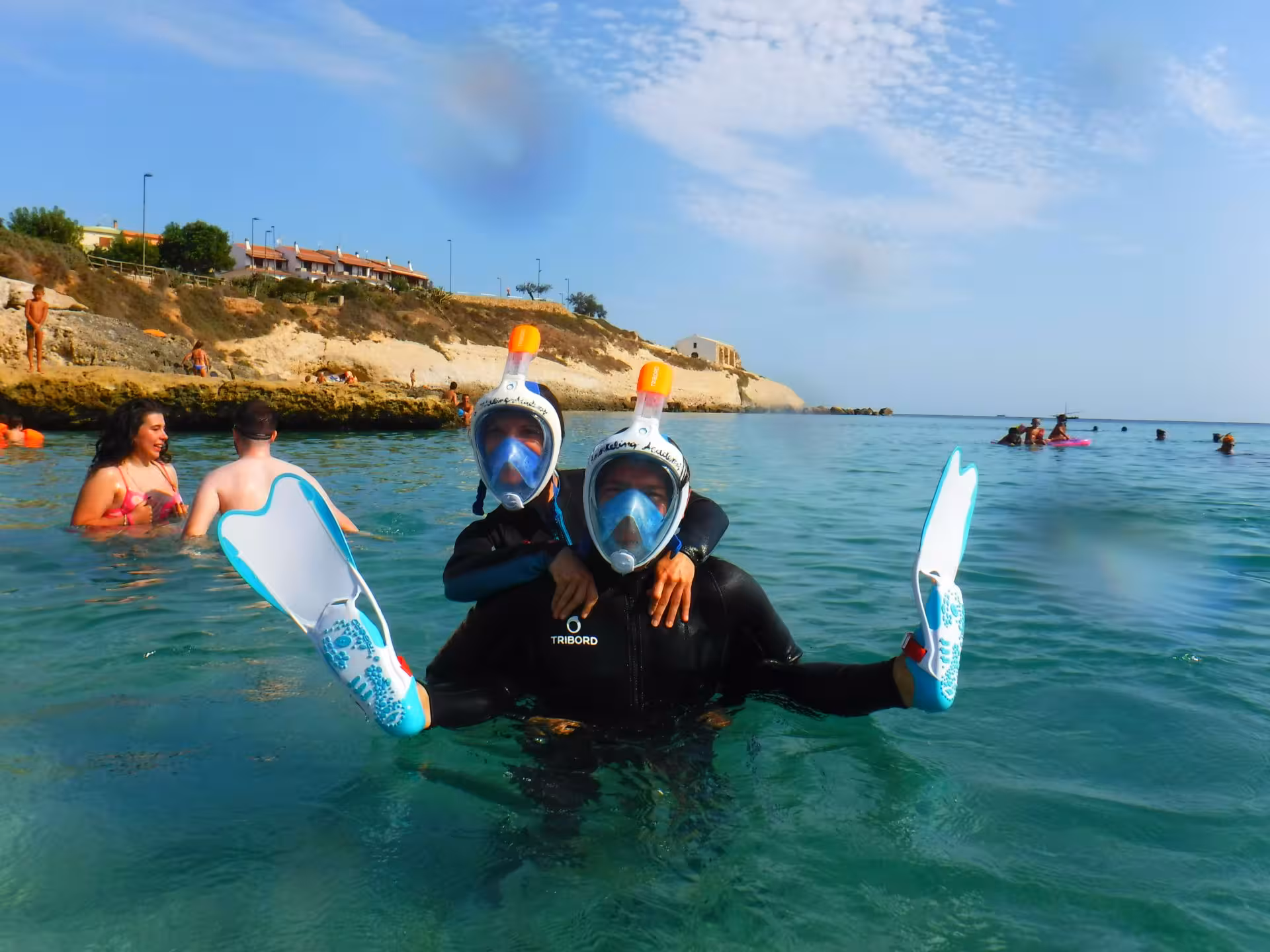 Snorkelers with fins and masks enjoying a sunny day in the scenic Bay of Balai, Porto Torres.