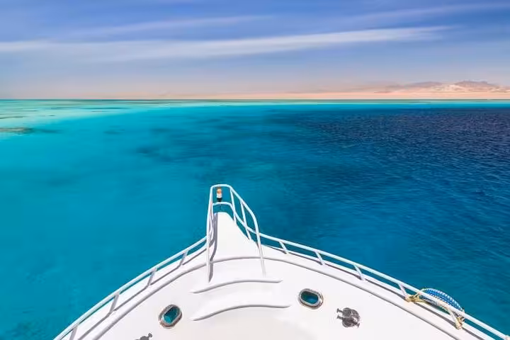 Boat bow view over turquoise Red Sea heading to Sataya Reefs for snorkeling with dolphins and lunch from Marsa Alam