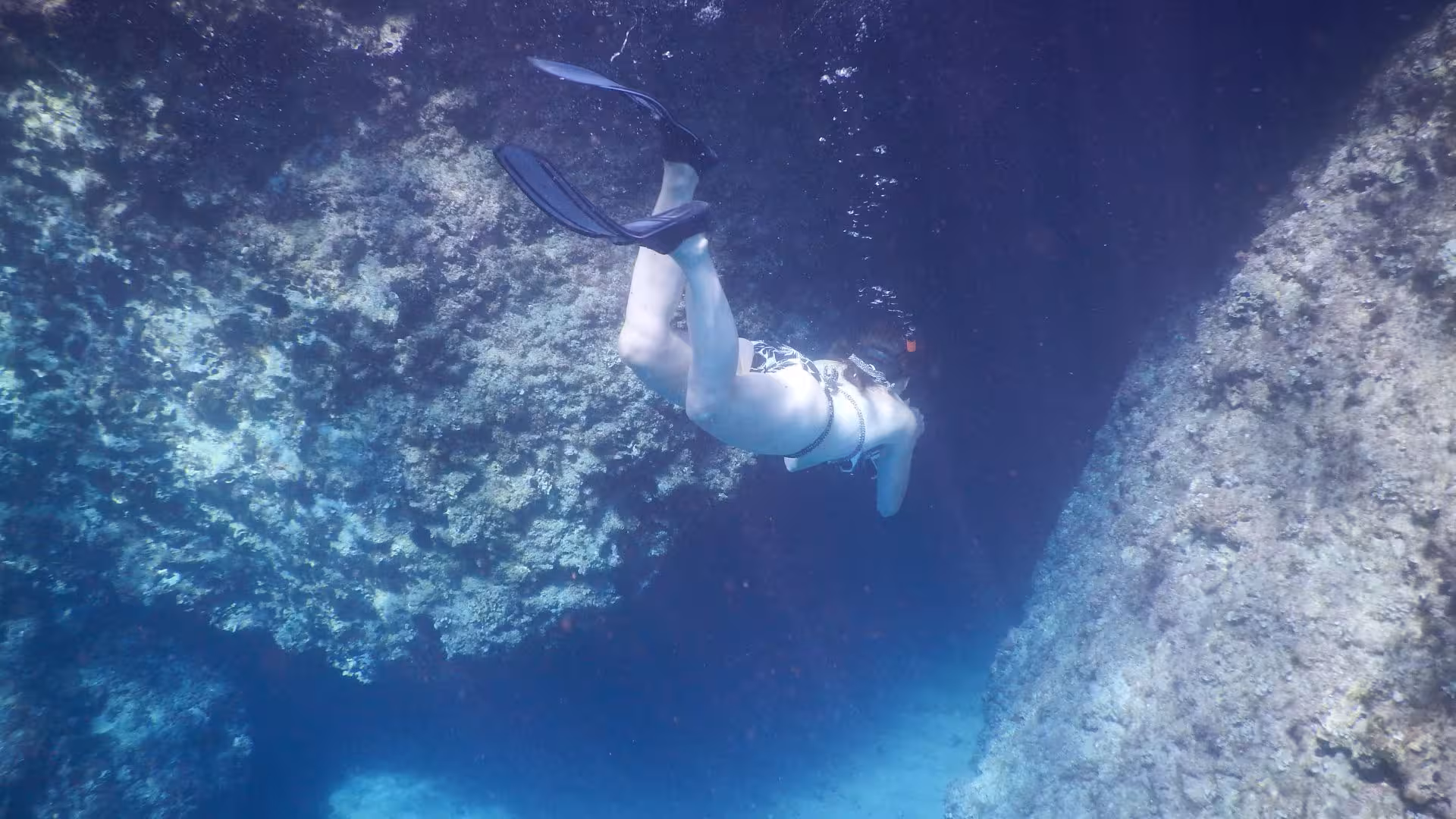 Snorkeler diving near rocky formations in the mesmerizing underwater landscapes of Orosei Gulf, Cala Gonone.