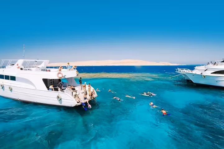 Snorkeling stop between yachts in crystal-clear Red Sea near Giftun Island, Hurghada sea trip with lunch and water sports