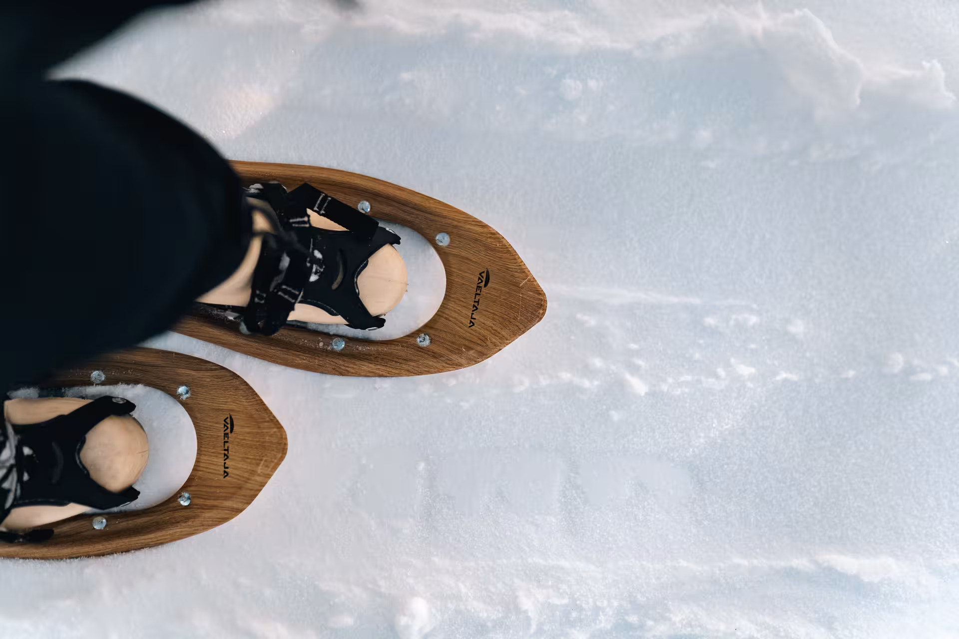 Close-up of snowshoes on fresh snow in Rovaniemi, ideal for Arctic snowshoeing tours.