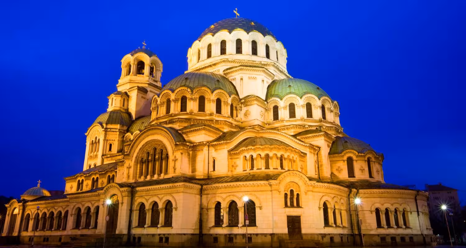Illuminated Sofia Cathedral against a deep blue sky, showcasing Bulgaria's architectural splendor on a Balkan journey.