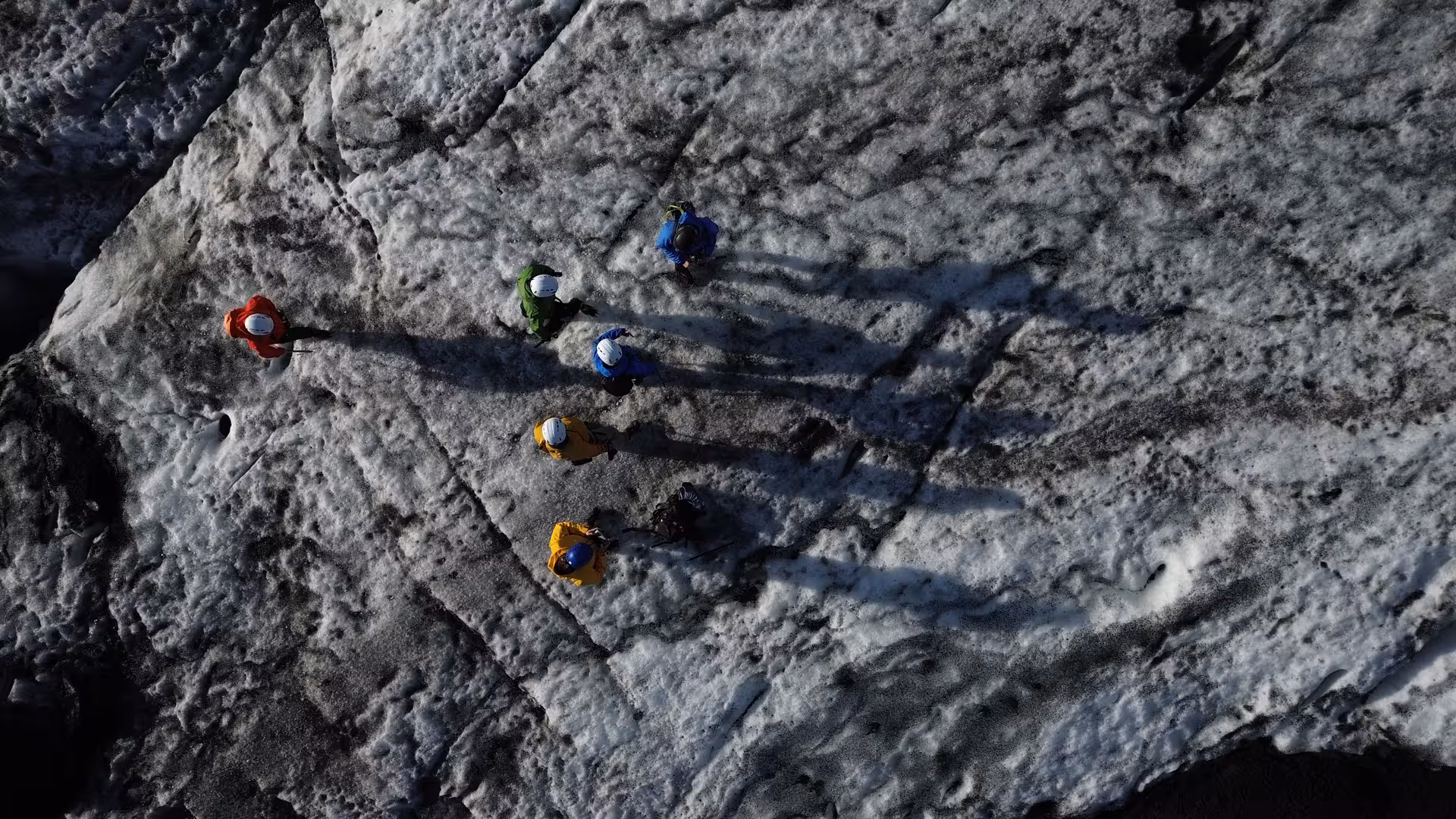 Aerial view of guided group trekking across Sólheimajökull glacier ice on an Iceland glacier hike adventure