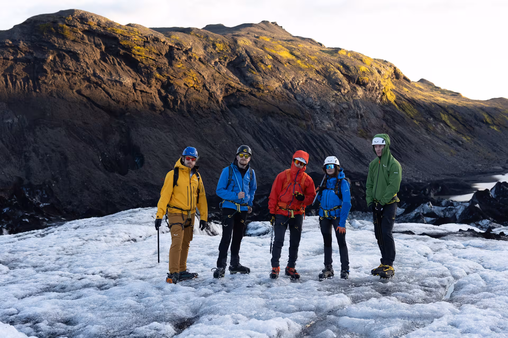 Guided group in helmets and crampons on Sólheimajökull glacier hike and ice climbing adventure, South Iceland