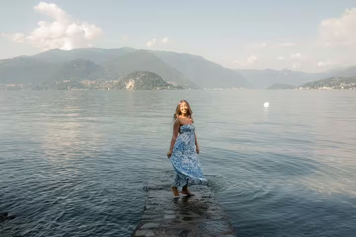 Solo traveler in blue dress on Lake Como pier, private photoshoot with personal travel photographer