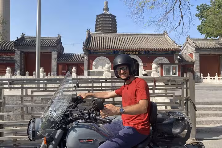 Solo traveler on a sidecar tour in front of a traditional Beijing temple, capturing the essence of a private city exploration.