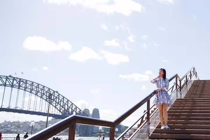 Solo traveler posing on Sydney Harbour Bridge steps during a private tour with personal travel photographer