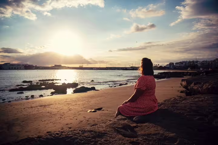 Solo traveler on Tenerife beach at sunset during private photoshoot with professional photographer, golden light