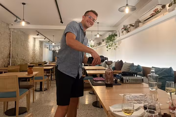 Sommelier preparing a guided tasting of five Port wines in a cozy Porto wine bar, with glasses ready on the table.