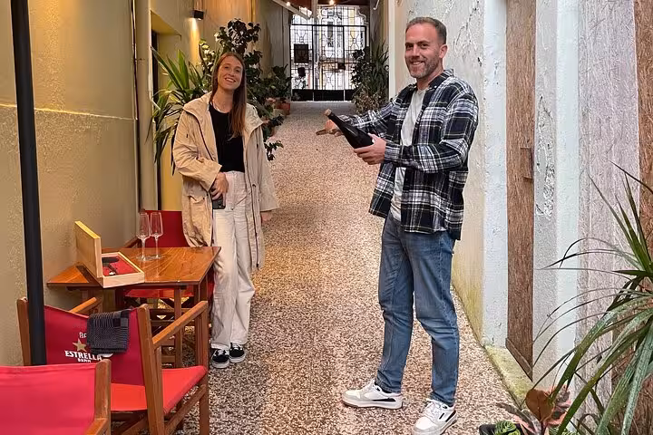 Sommelier introducing a bottle of Port in a charming Porto alley, setting the scene for an intimate five-wine tasting.