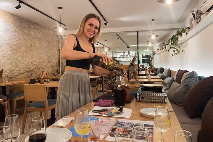 Sommelier pouring Port into a decanter during a guided tasting of five Port wines in a cozy Porto, Portugal wine bar