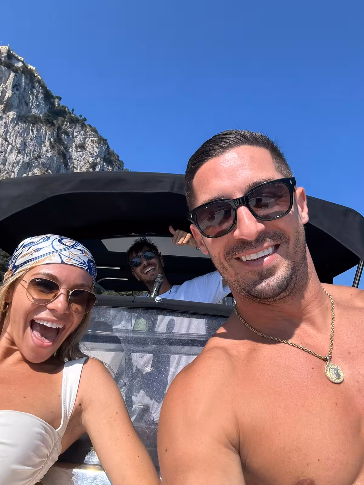 Smiling tourists enjoying a sunny boat ride from Sorrento to Amalfi, capturing fun moments on the tour.