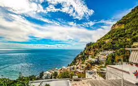 Panoramic view of Amalfi Coast cliffs, blue Tyrrhenian Sea and hillside villages on scenic Sorrento boat excursion