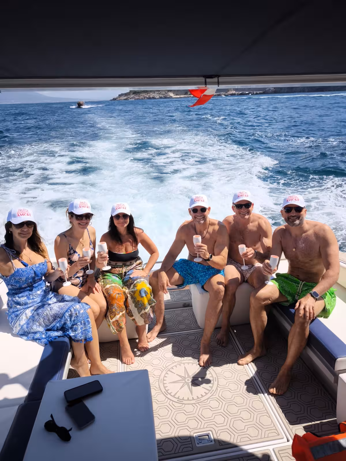 Group of friends celebrating with drinks on a boat tour from Sorrento to Amalfi and Positano.