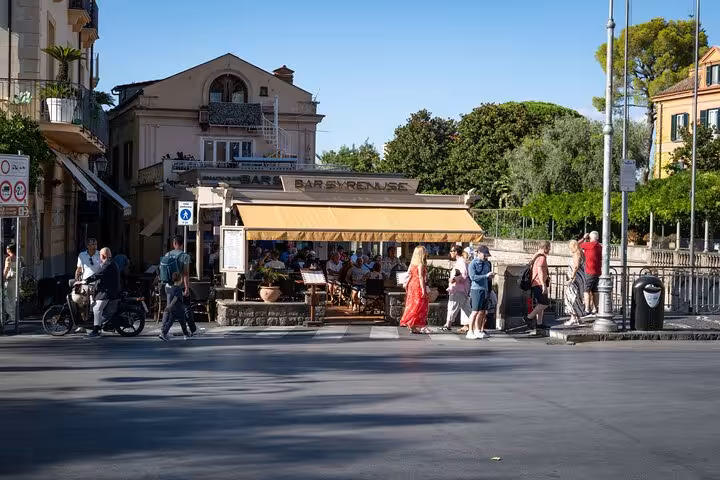 Outdoor cafe in Sorrento bustling with people enjoying food and drinks under a sunny sky on the Bites & Sips Tour.