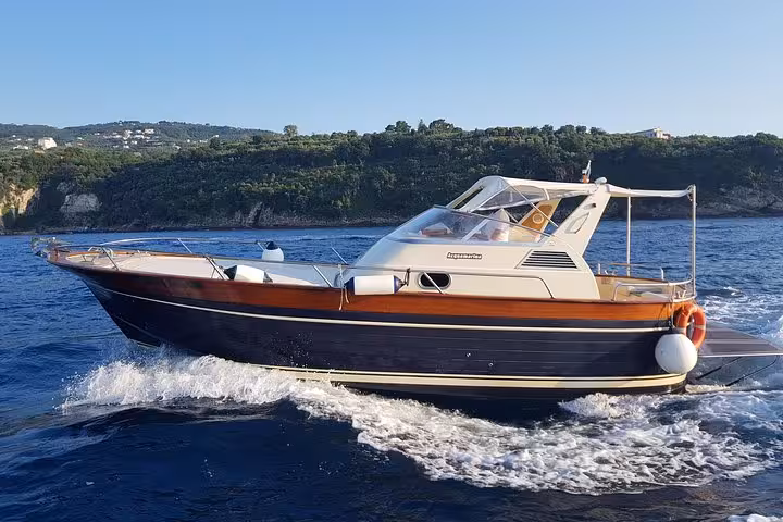 Elegant boat cruising from Sorrento to Capri on a sunny day, perfect for a small group tour experience.