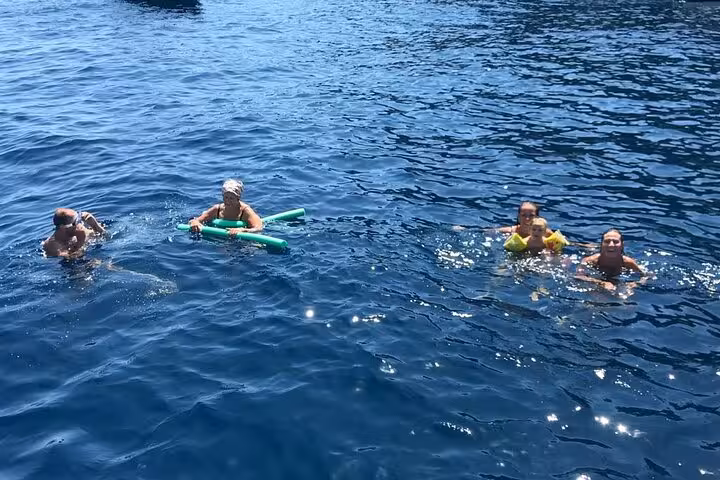 Tour participants swimming and relaxing in the refreshing waters of the Sorrento Coast on a sunny day.