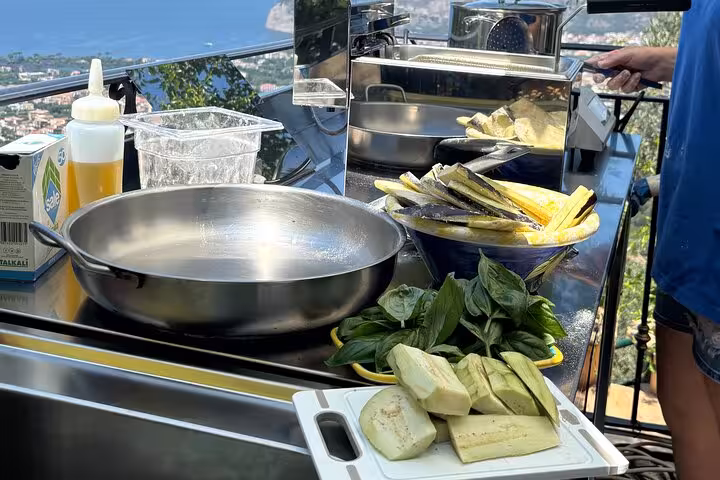 Fresh eggplant and basil on a cooking station with panoramic views during a Sorrento culinary experience.
