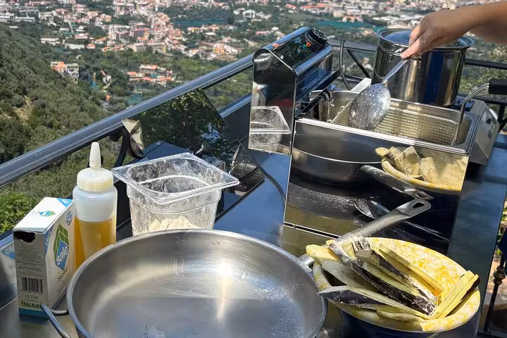 Prepare fresh ingredients with a stunning Sorrento landscape backdrop in a hands-on Italian cooking class experience.