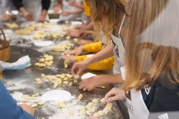 Participants in Sorrento cooking class handcraft fresh pasta on a flour-dusted table, learning Italian culinary traditions.