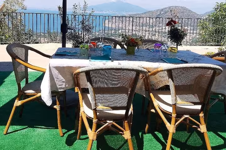 Outdoor table set for dining with a stunning coastal view, ideal for a farm-to-table pizza and cheese experience.