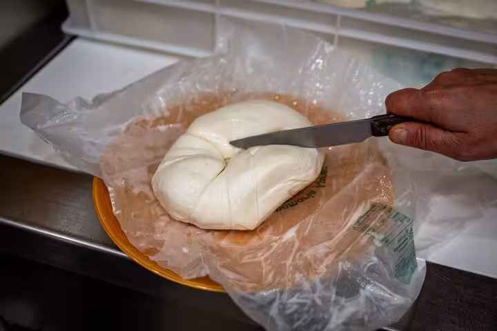 Fresh mozzarella being sliced on a Sorrento Bites & Sips Tour, showcasing local artisanal cheese-making.