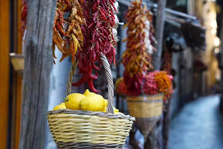 Vibrant Sorrento street with hanging peppers and lemons in a basket, perfect for a guided food tour experience.