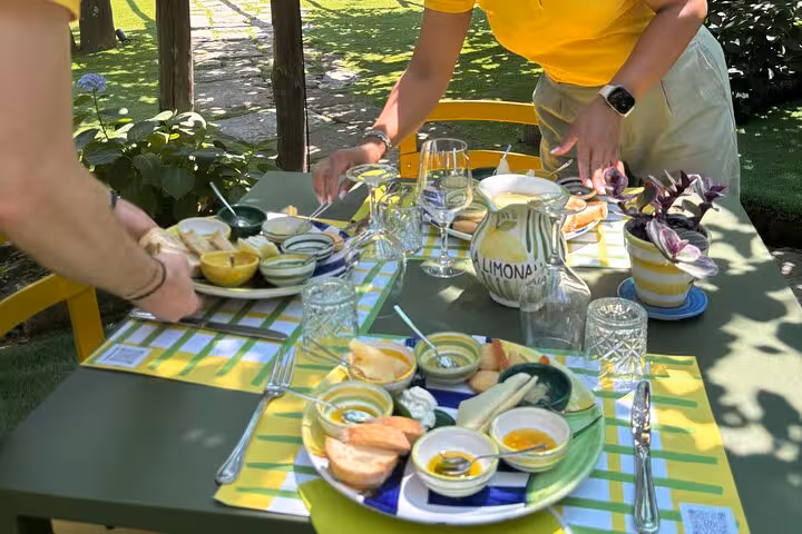 Guests enjoy a vibrant Sorrento lemon grove tasting with local delicacies and refreshing limoncello on a sunny patio.
