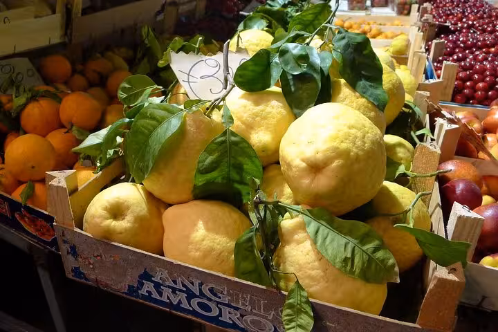 Crate of large, fresh Sorrento lemons at a vibrant market, showcasing the region's renowned citrus produce.