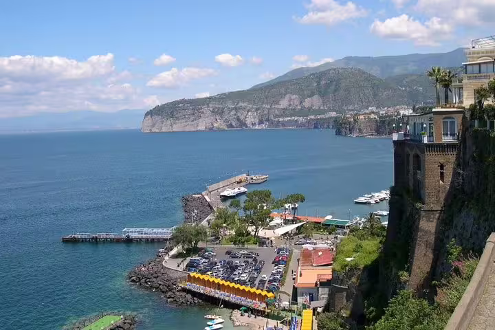 Panoramic view of Sorrento’s Marina Piccola harbor, seaside cliffs and Mount Vesuvius on a scenic Amalfi Coast shore excursion