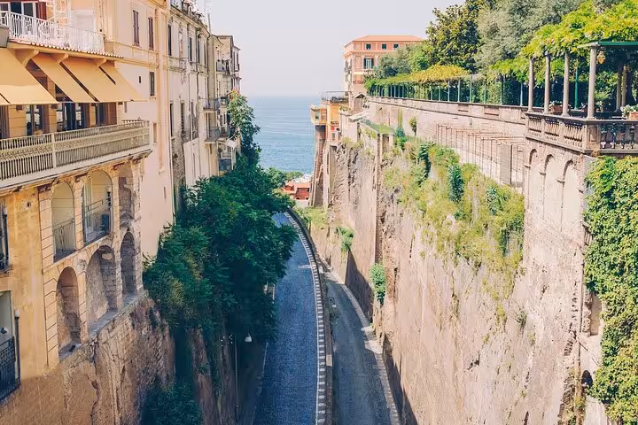 Charming narrow street in Sorrento with cliffside views and ocean backdrop, perfect for exploring local culture.