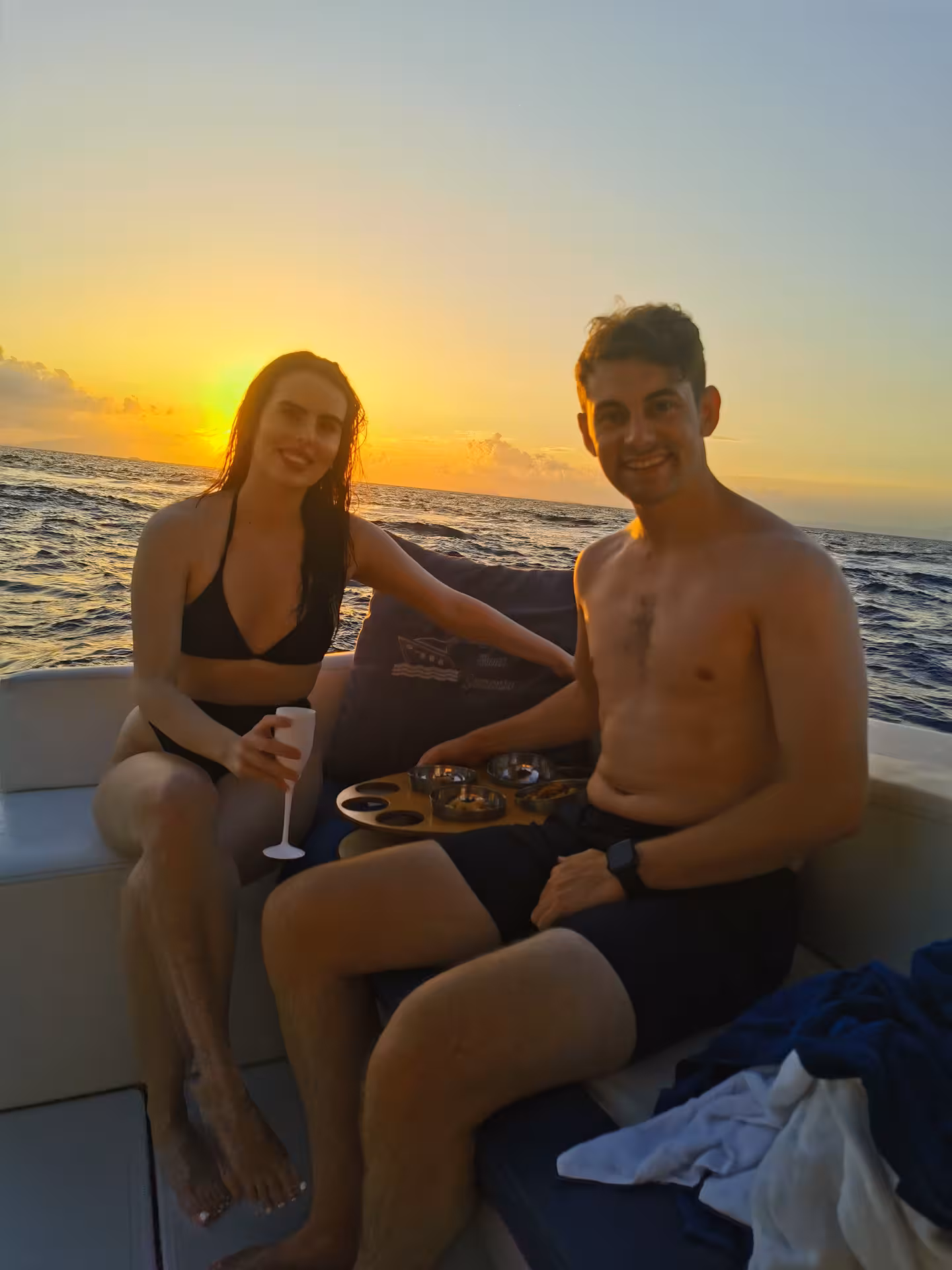 Couple enjoying a Sorrento sunset boat tour with drinks, capturing a romantic experience on the water.