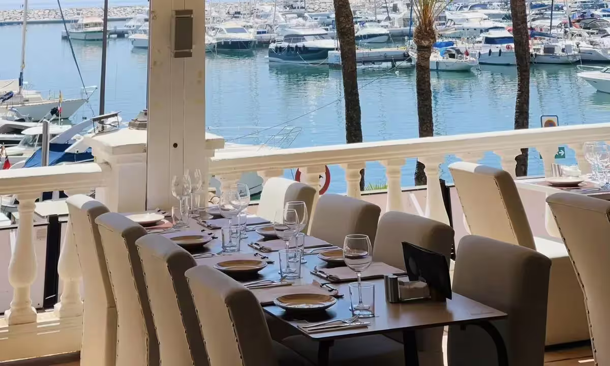Elegant dining setup overlooking yachts in Puerto de la Duquesa marina, a highlight of the Sotogrande minicruise.