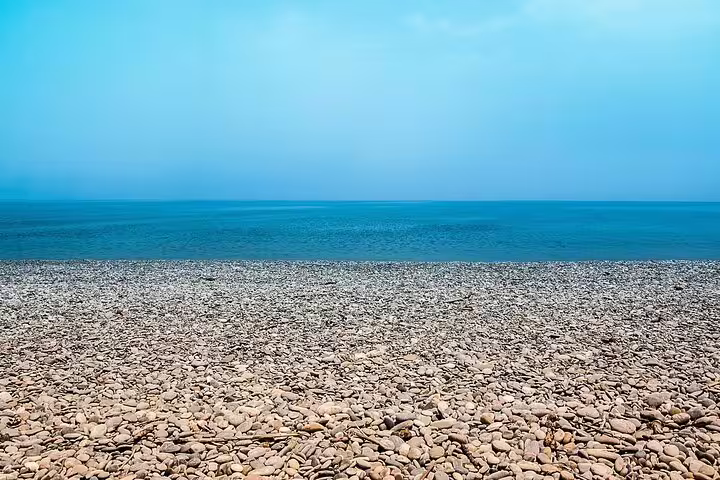 Tranquil pebble beach at Sougia with clear blue sea, perfect for sunbathing and seaside relaxation.