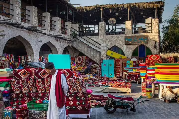 Vibrant Souq Waqif in Doha featuring colorful textiles and traditional architecture on Doha Transit City Tour.
