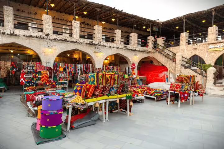 Colorful textiles and traditional goods displayed at Souq Waqif in Doha, capturing the essence of Qatari market life.