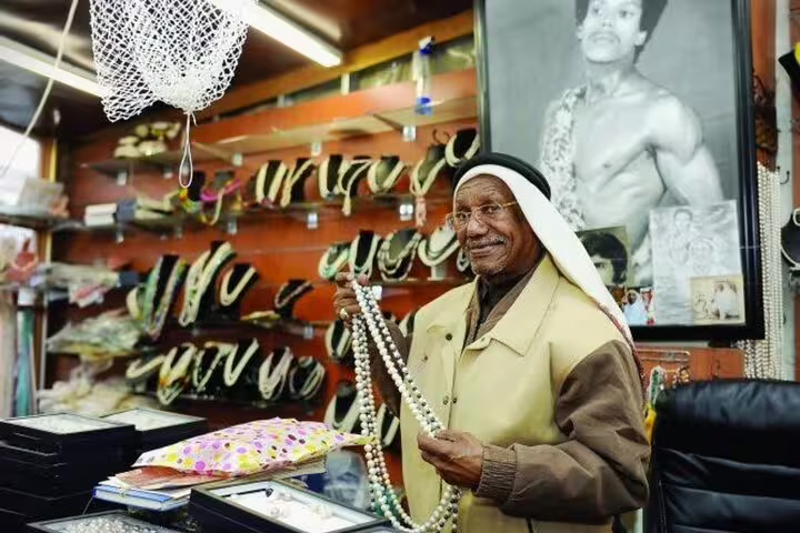 Local vendor showcasing pearl necklaces at Souq Waqif in Doha, offering a glimpse into Qatar's traditional market culture.