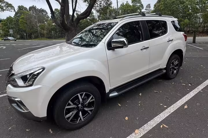 Comfortable white SUV parked in a scenic lot, ready for South Coast private daily group tour pickup.