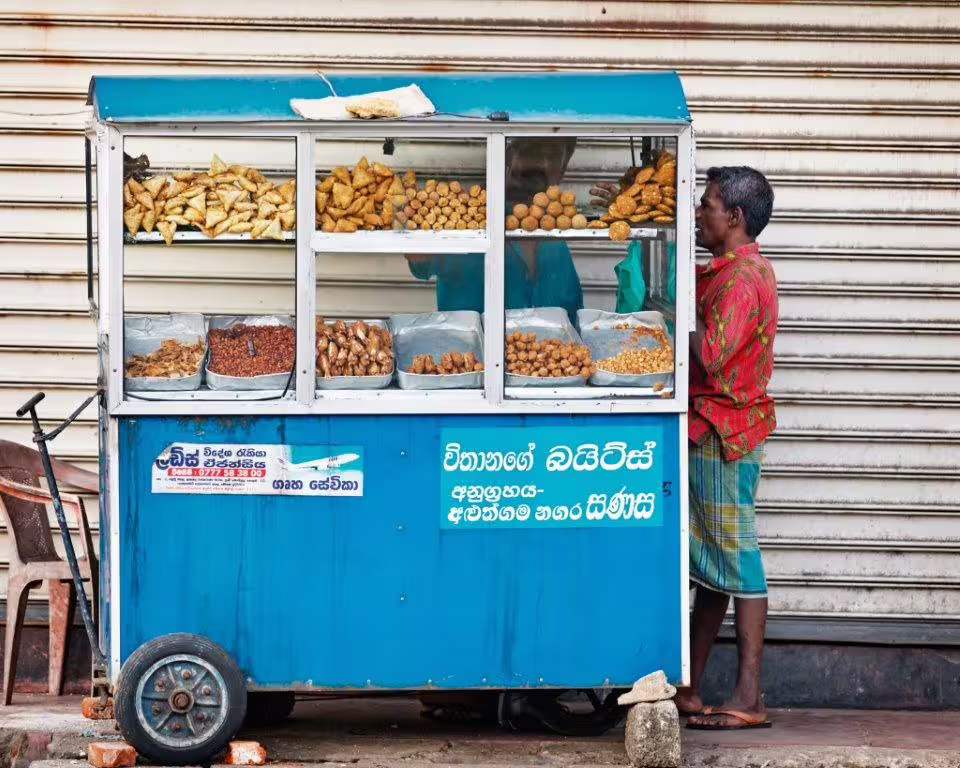 Local street vendor selling traditional snacks from a blue cart on the Southern Coast tour.