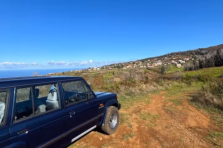 4x4 jeep on a dirt track above southwest Madeira villages, scenic off-road adventure with ocean views
