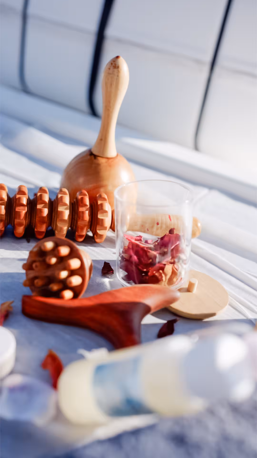 Spa massage tools and rose petals on a yacht deck, part of Wellness & Sea Breeze relaxation cruise