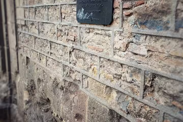 Plaque on a brick wall marking significant Spanish Civil War events in Barcelona, part of the walking tour.