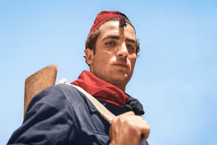 Man in traditional cap and scarf holding rifle, symbolizing Spanish Civil War themes and Franco's dictatorship tour.