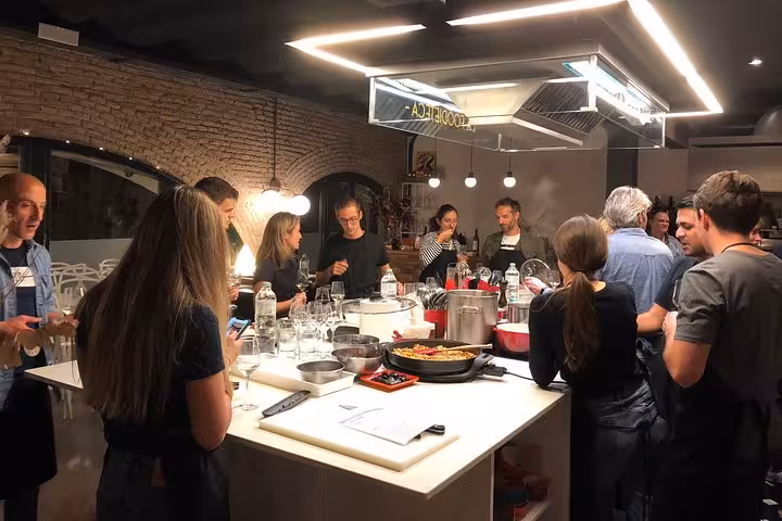 Participants engaging in a hands-on Spanish cooking class, preparing paella and tapas in a designer loft.