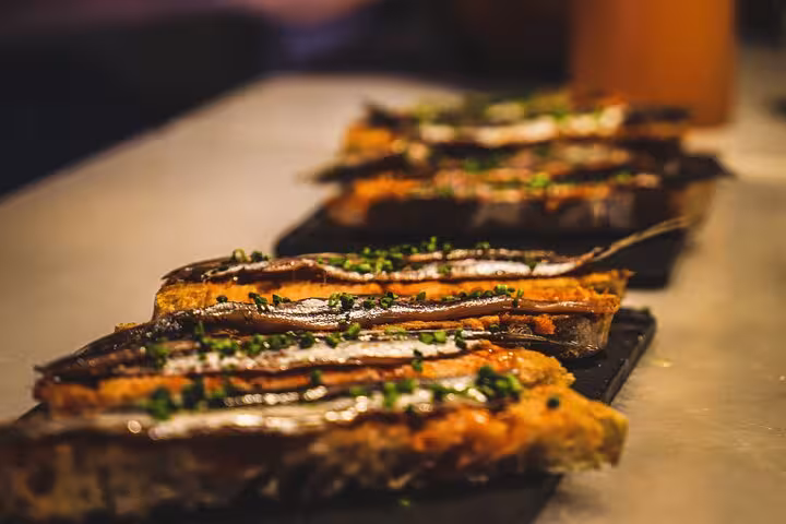 Close-up of delicious Spanish tapas featuring anchovies on toasted bread, highlighting authentic Barcelona flavors.